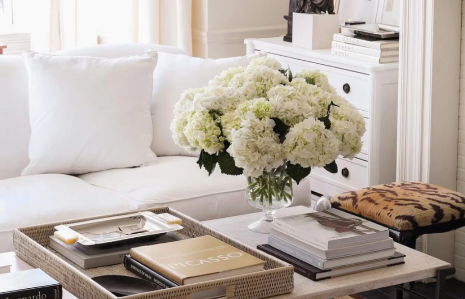 A white sofa, hydrangeas and a tray of coffee table books
