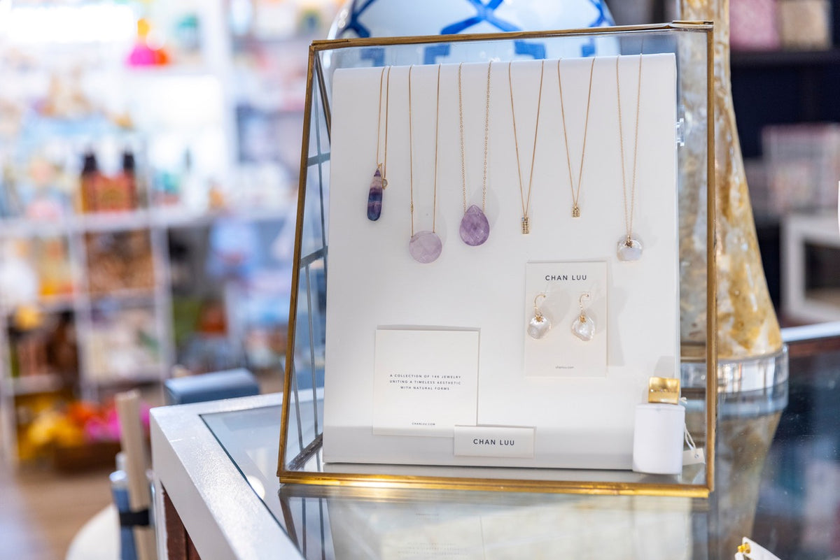Pendant necklaces displayed in a gold frame